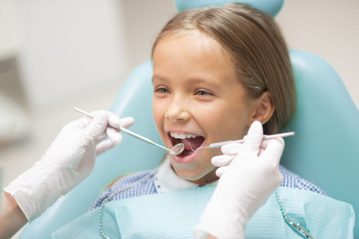 Cute girl smiling while visiting dentist at the weekend